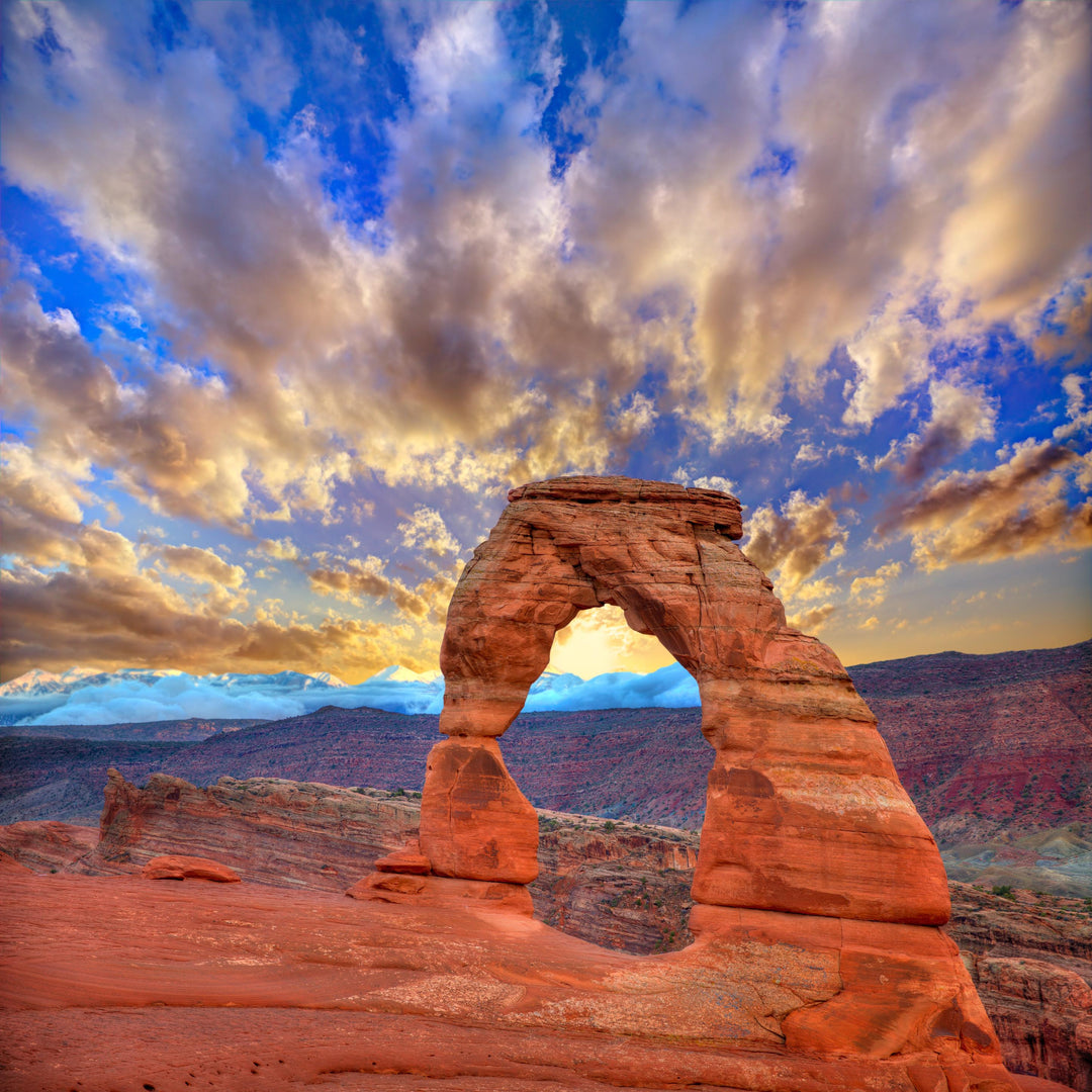 A photograph of Delicate Arch at Arches National Park, Moab, Utah, with a dramatic sky in the background.
