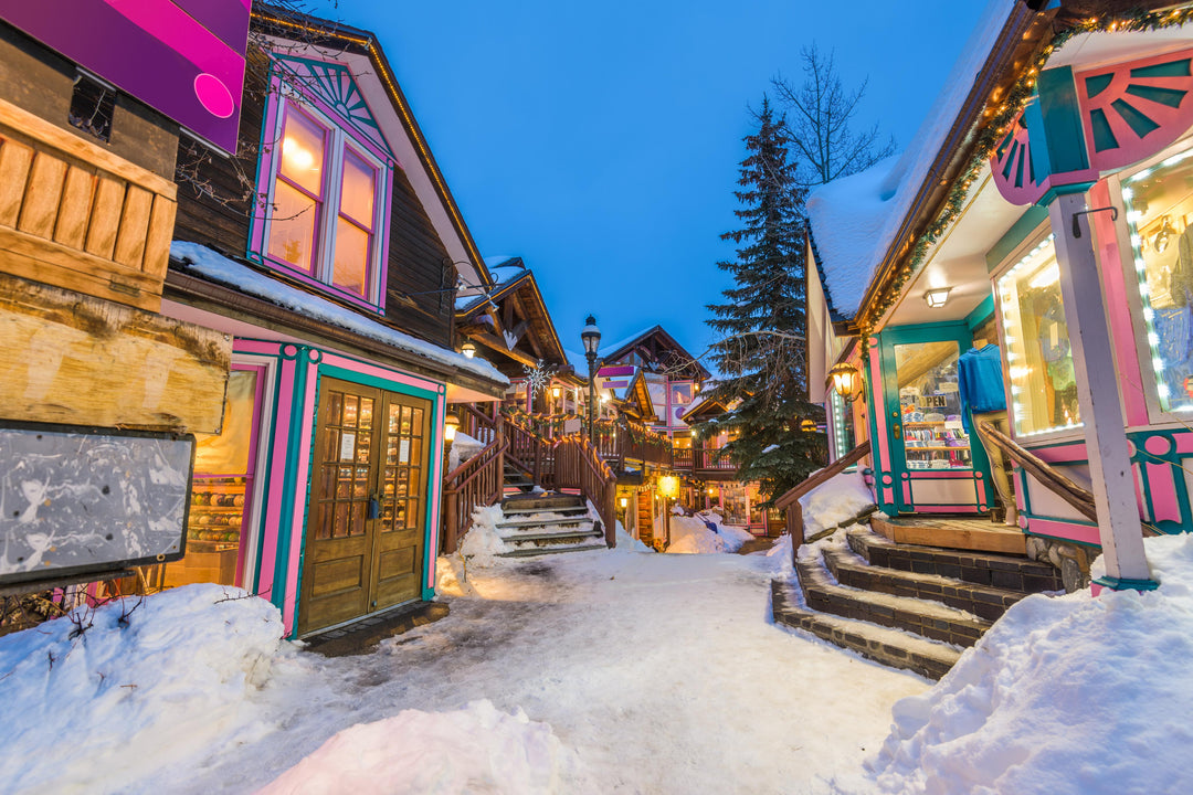 A snowy street in Breckenridge, Colorado with colorful buildings and Christmas decorations.