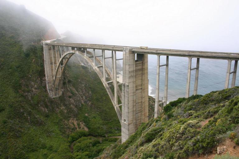 Bridge over a body of water with mountains in the background