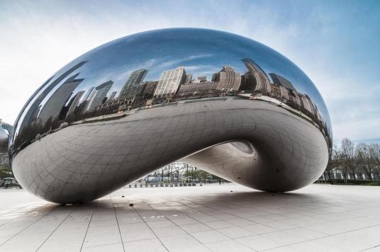 A photograph of Cloud Gate, a famous sculpture in Chicago, reflecting the cityscape.