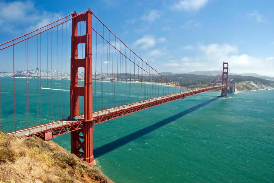 The Golden Gate Bridge over San Francisco Bay with a clear blue sky in the background.