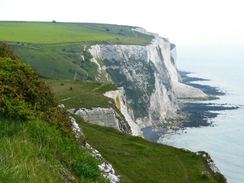 Cliffs of White Cliffs of Dover with green grass and ocean.
