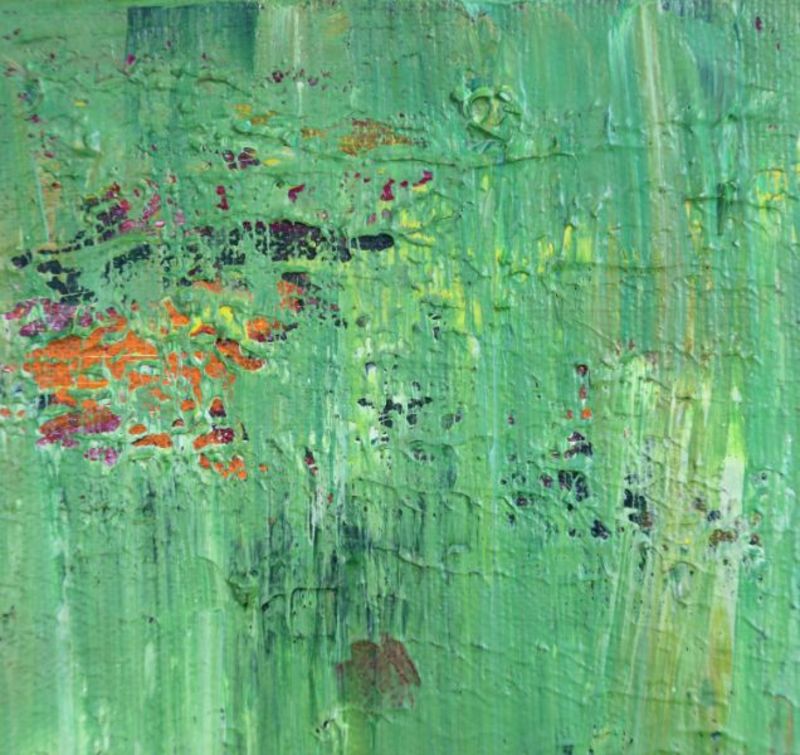 Close-up view of a section of a green and orange abstract painting.